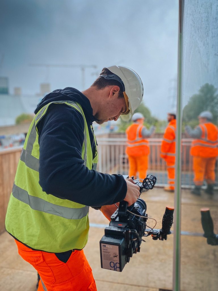 camera operator filming on a construction site