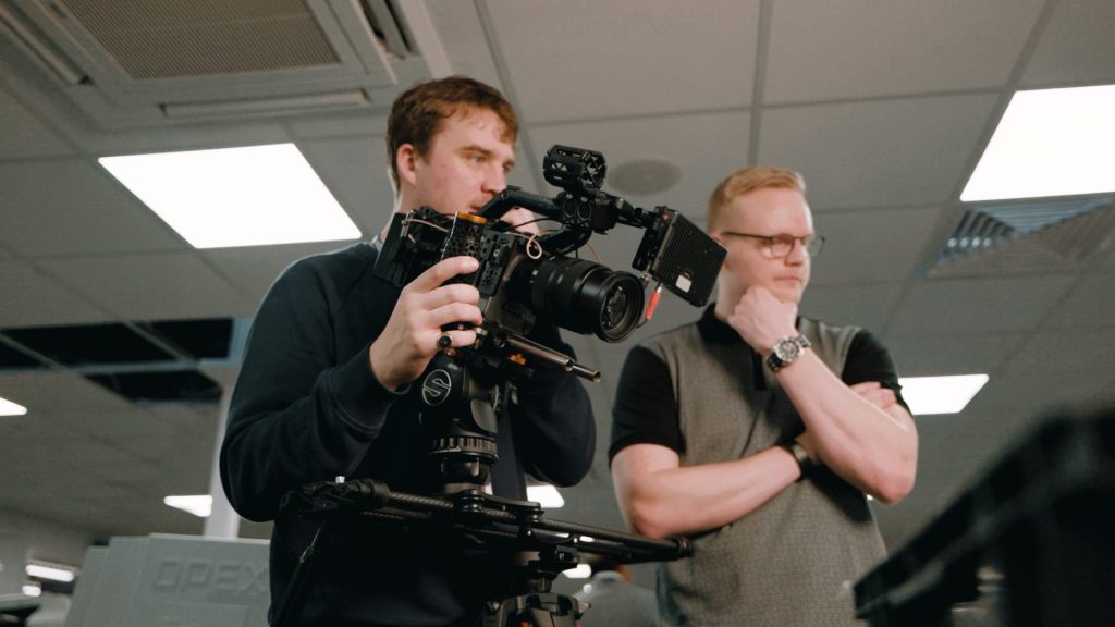 video producer and camera operator filming a corporate video on location.