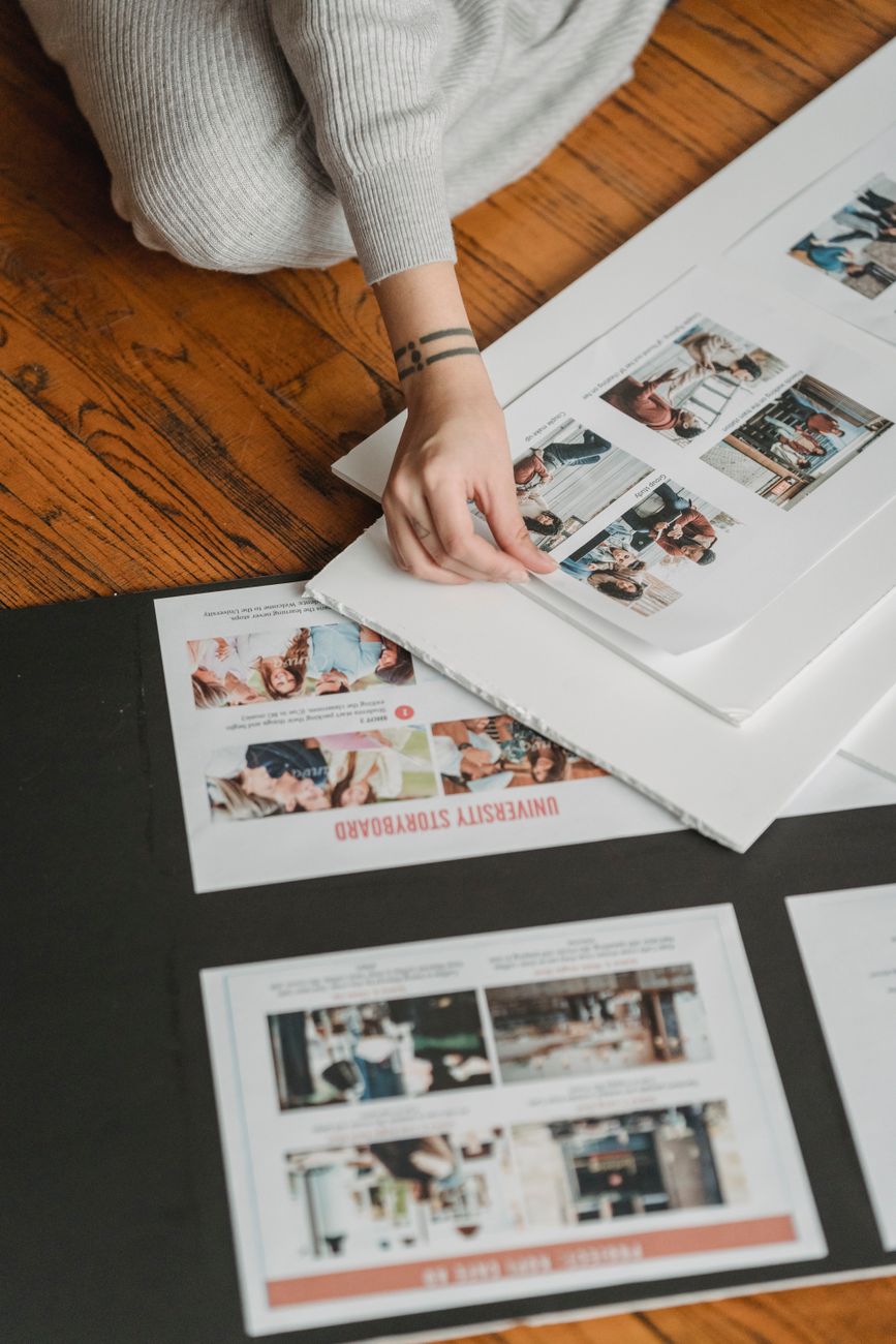 crop unrecognizable woman forming photo album on floor